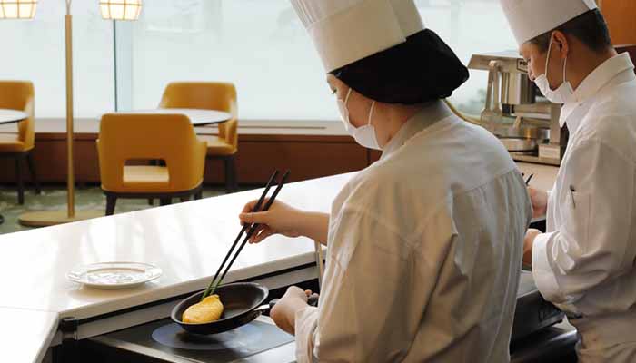 オムレツを焼く社員ふたり